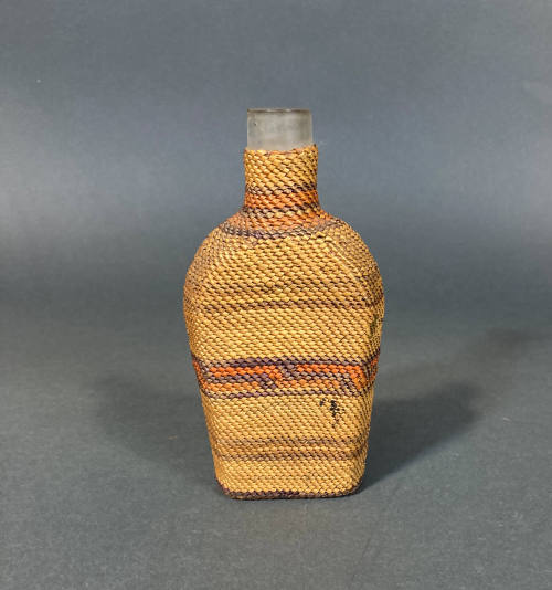 Glass bottle with shaped basket